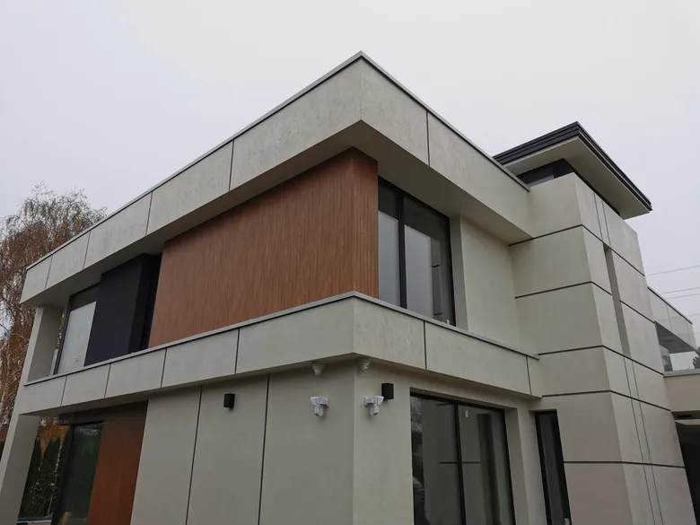 Gebäude mit Aluminiumfassade: helle Platten und ein Akzent in Holzoptik