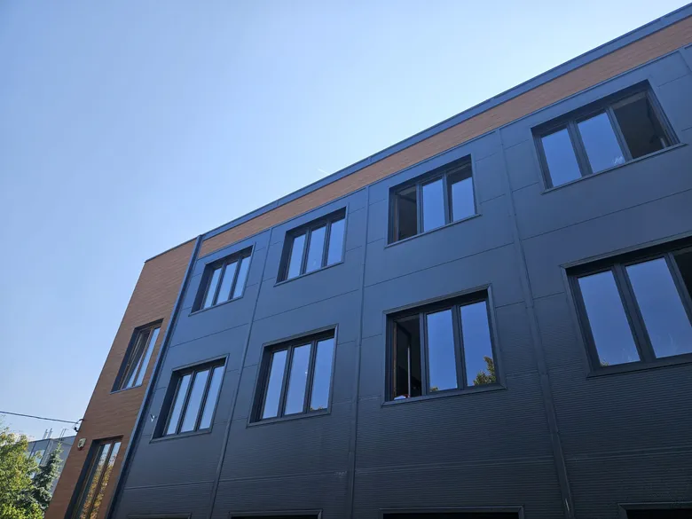 Bürogebäude mit graphitfarbener Aluminiumfassade und einem Holzakzent