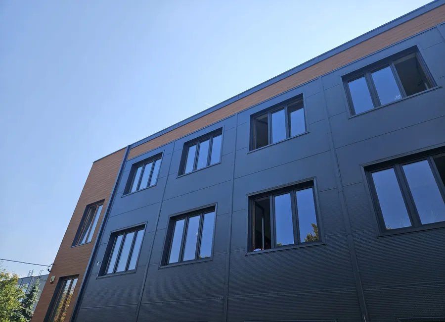 Bürogebäude mit graphitfarbener Aluminiumfassade und einem Holzakzent