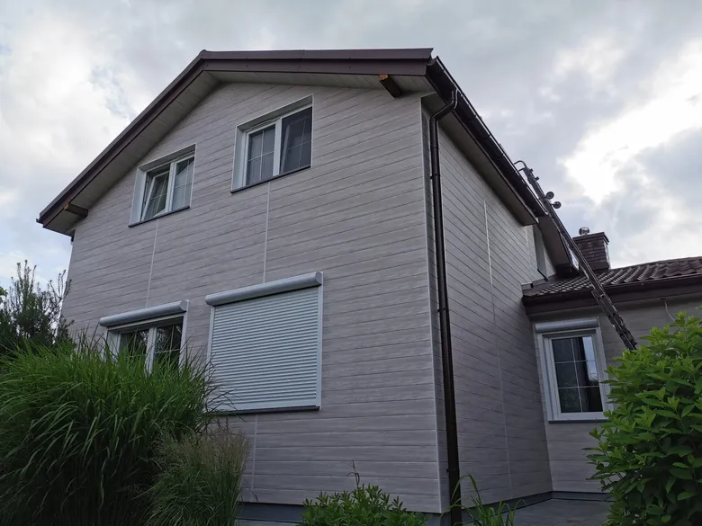 Einfamilienhaus mit grauer Aluminiumfassade in Holzstruktur